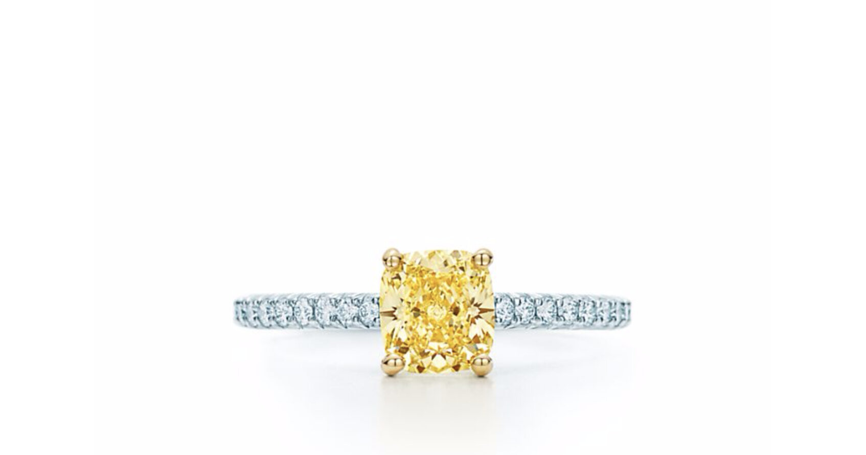 Cushion yellow center diamond cut with perfectly aligned facets and a slightly square shape, pave set white diamonds provide a contrast that make the cushion diamond pop